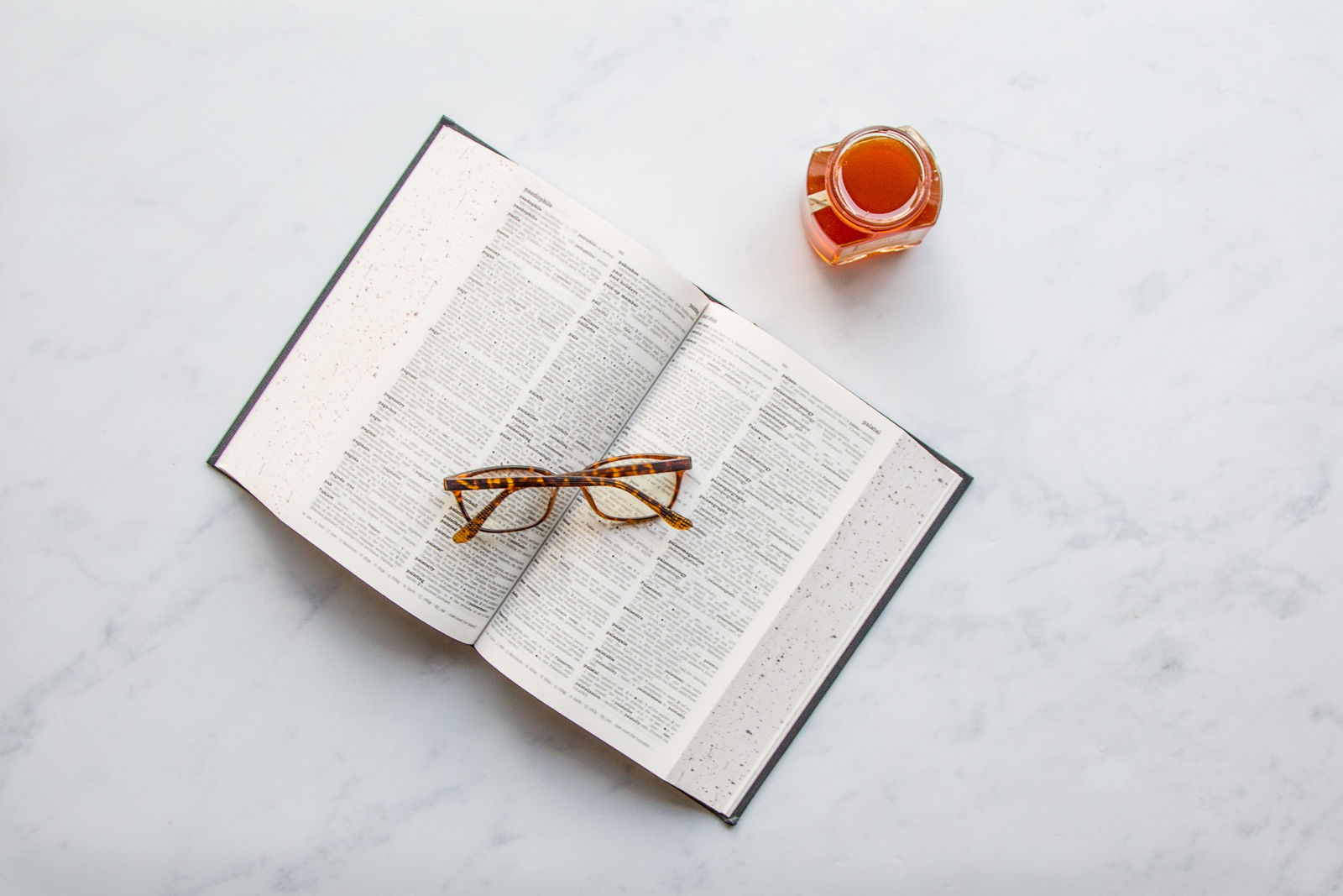 a book, some glasses and raw honey