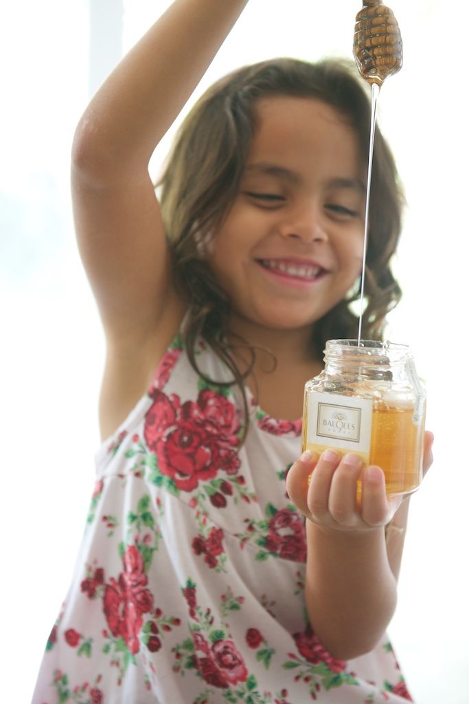 a young girl with a jar of raw honey