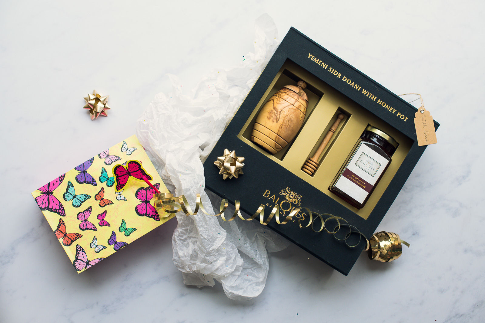 gift wrapping of box containing wooden honey pot, honey drizzler and honey jar