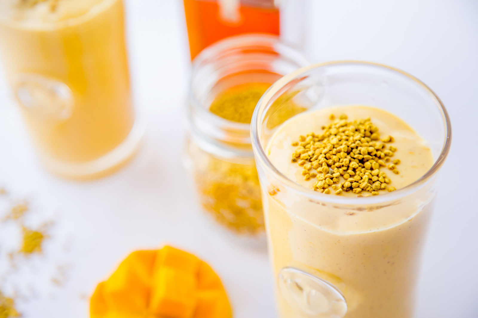 Mango smoothie topped with bee pollen and raw honey