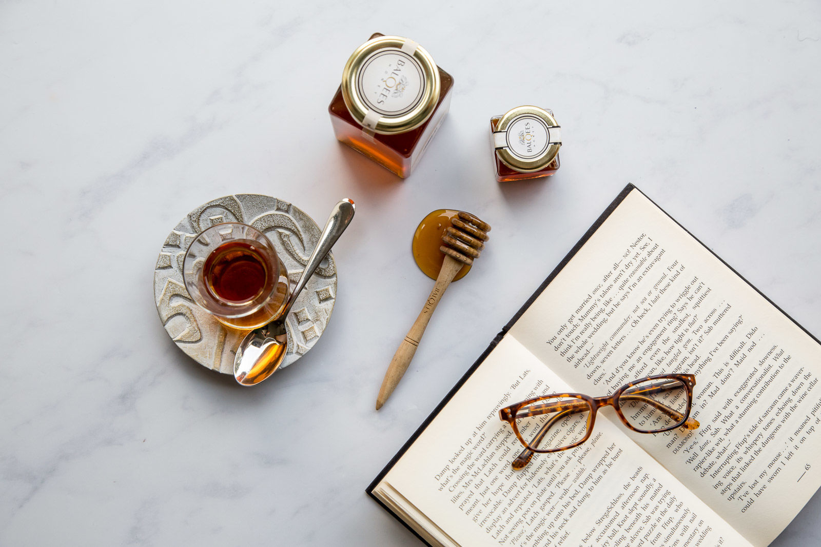 a book, some glasses, tea and raw honey