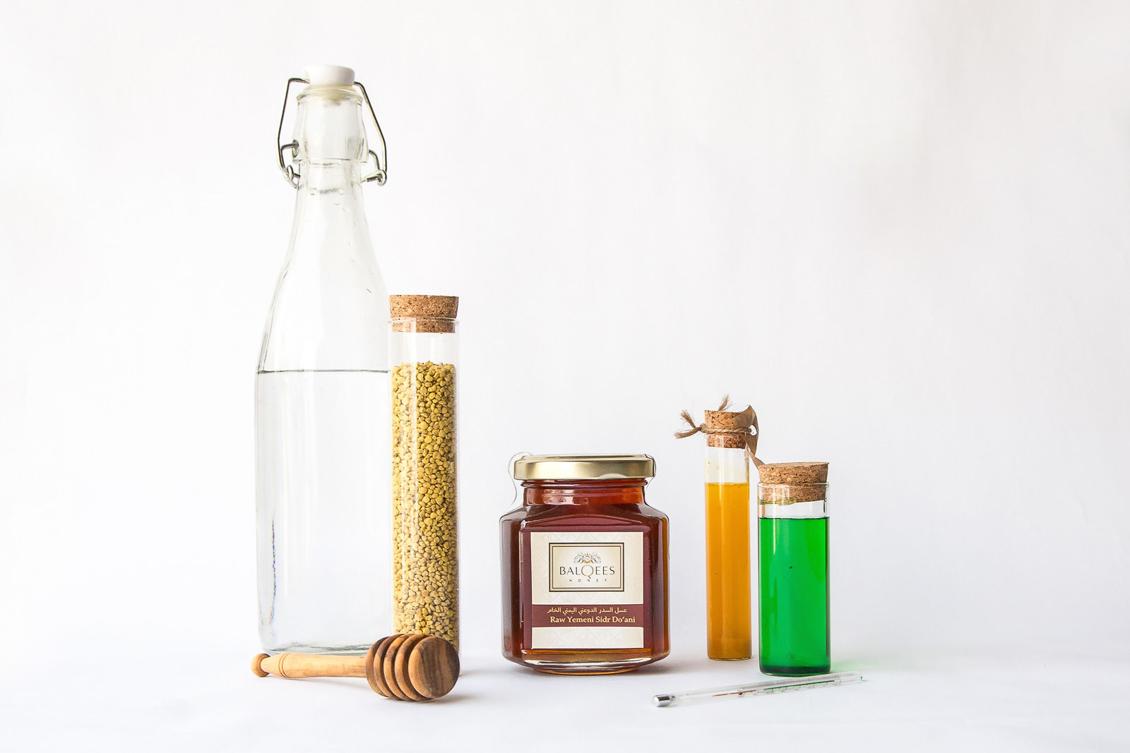 bottles, a thermometer and a jar of raw honey