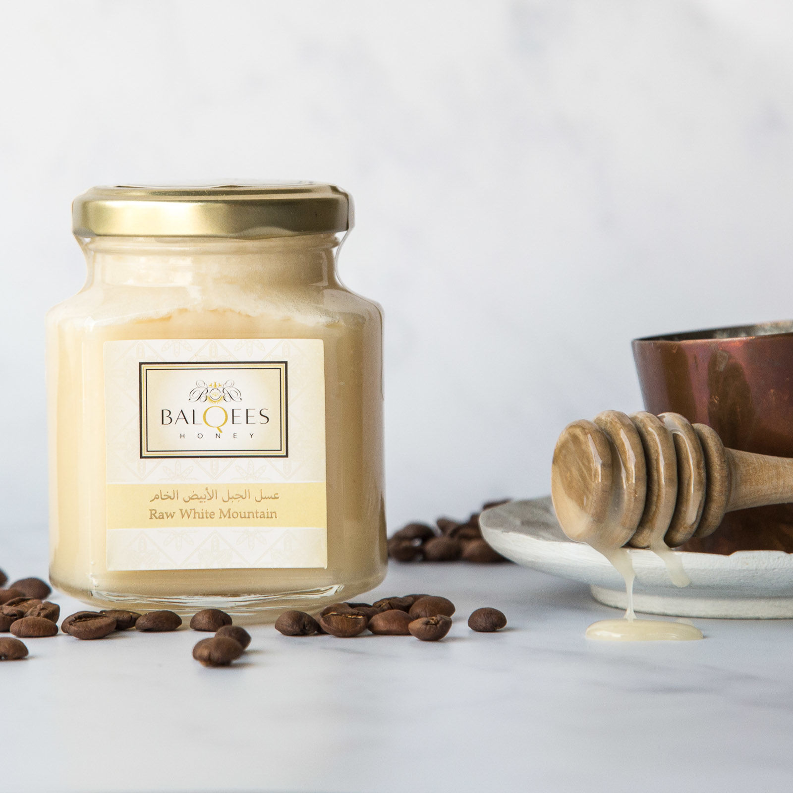 jar of raw white mountain honey with coffee and a honey drizzler